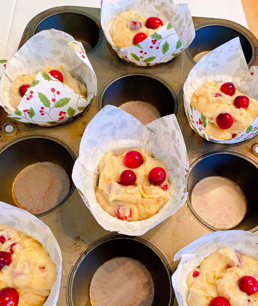 Muffin cup filled with Cranberry Orange Muffin dough ready to bake.