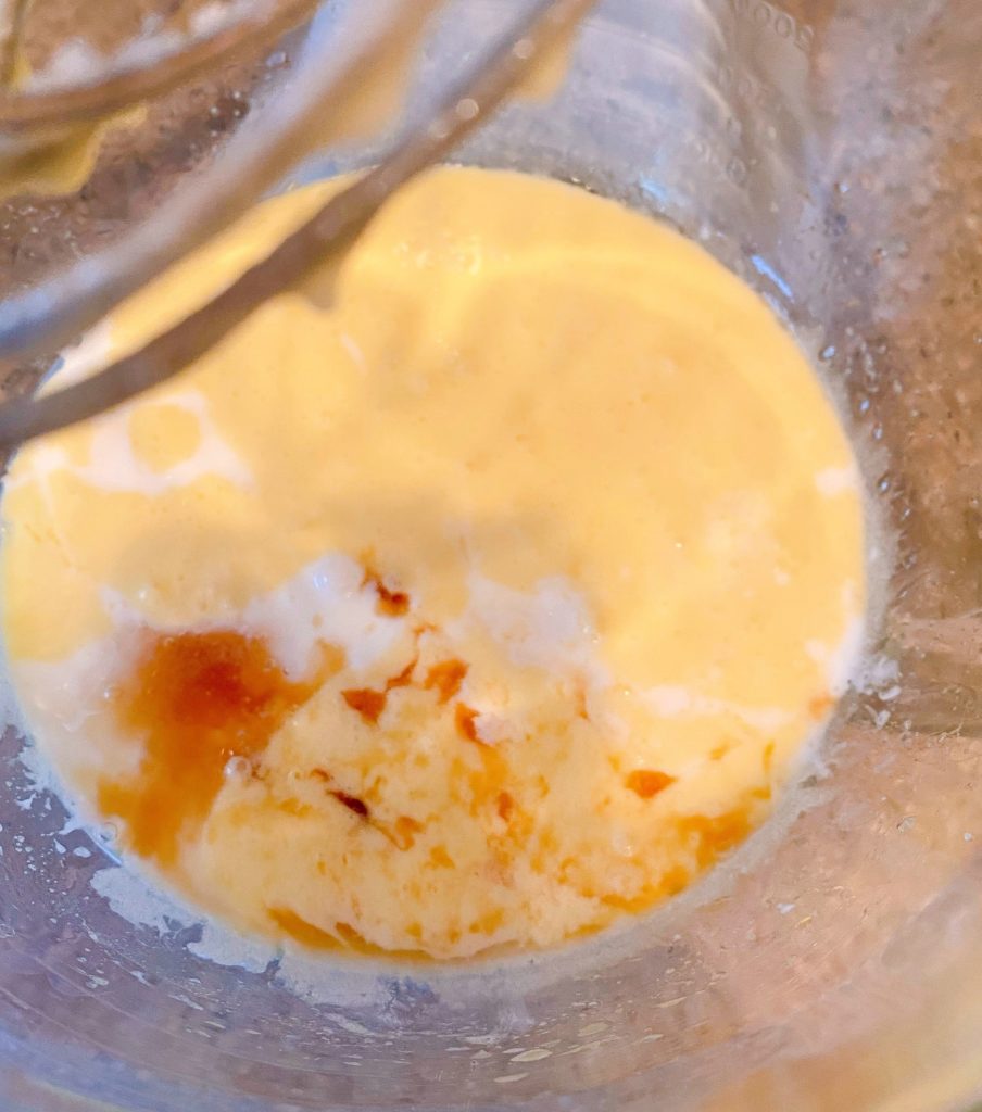 Adding buttermilk and vanilla to wet ingredients in mixer.