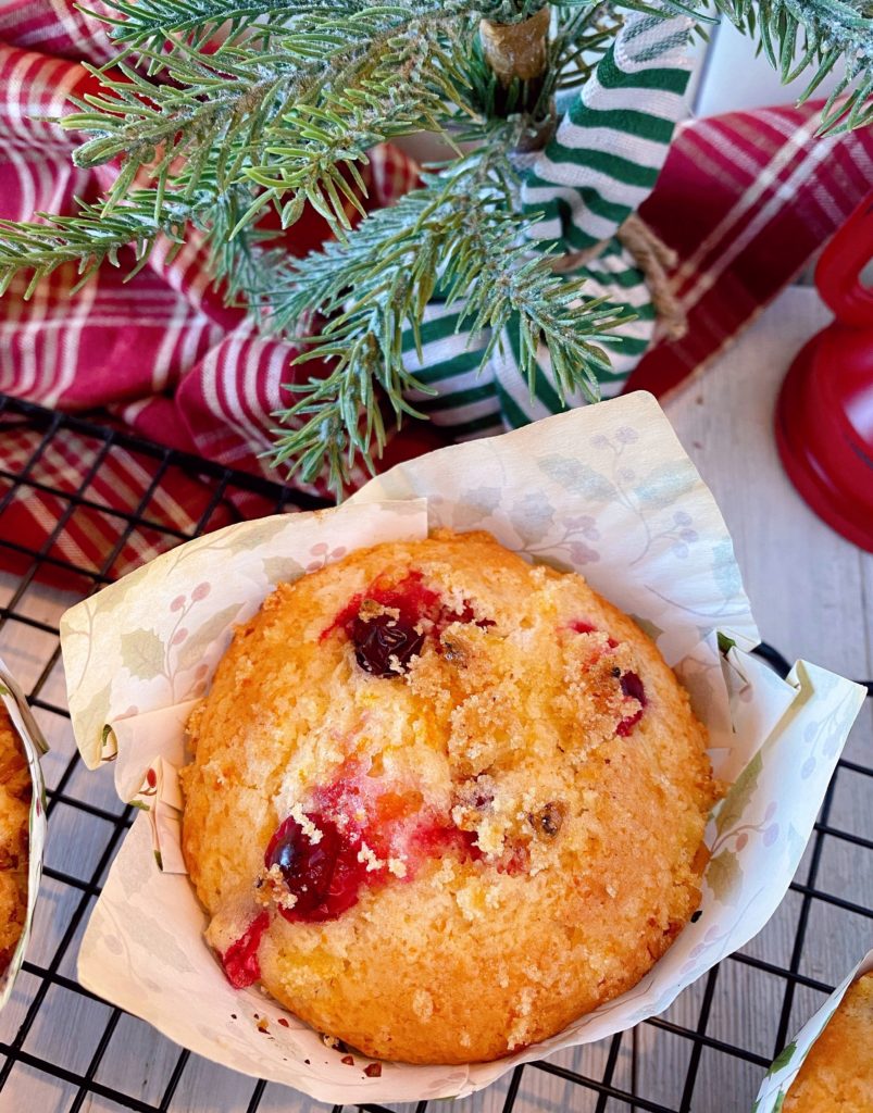 Cranberry Orange Muffin in a Christmas liner on a cooling rack.