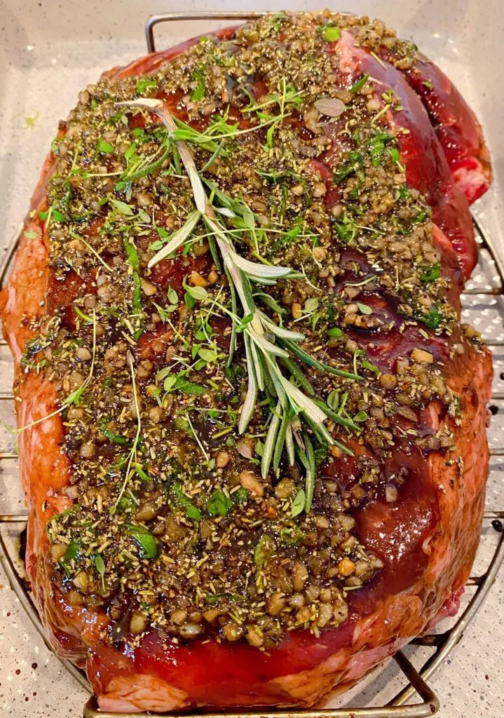 Herb Paste and fresh herbs placed on top of Cross Rib Roast ready to go into the oven.
