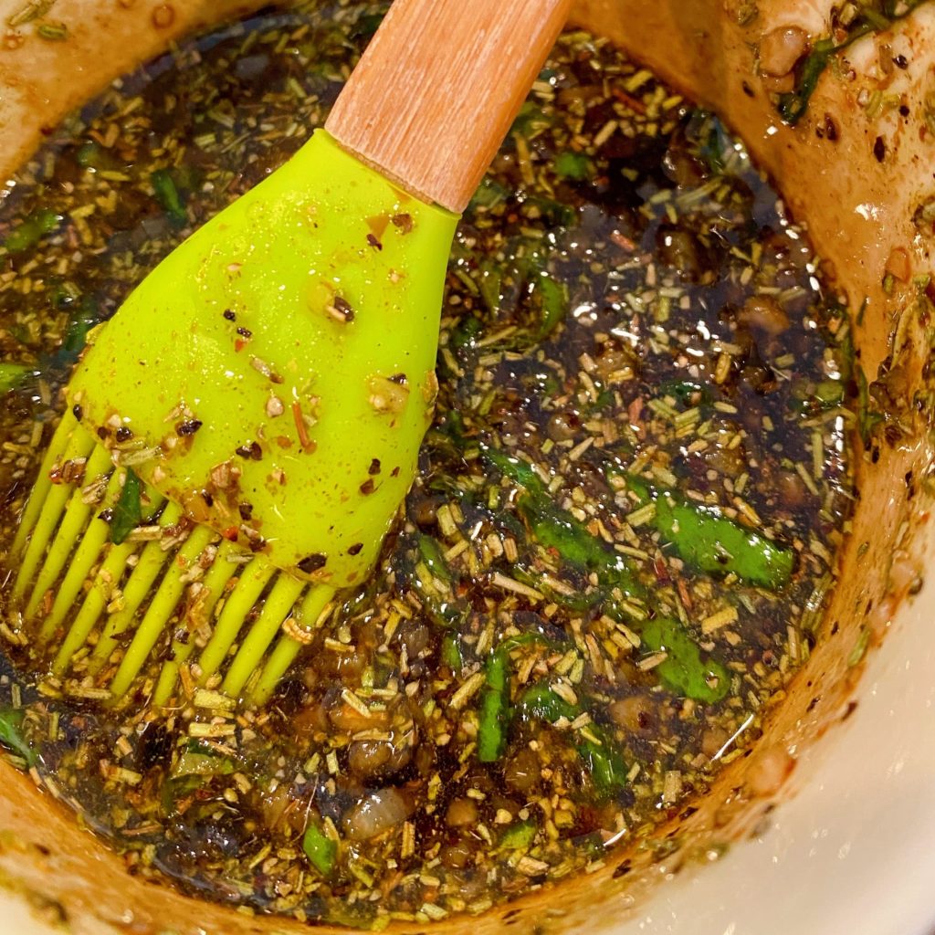 Mixed Herbs and Olive Oil in small bowl with basting brush.
