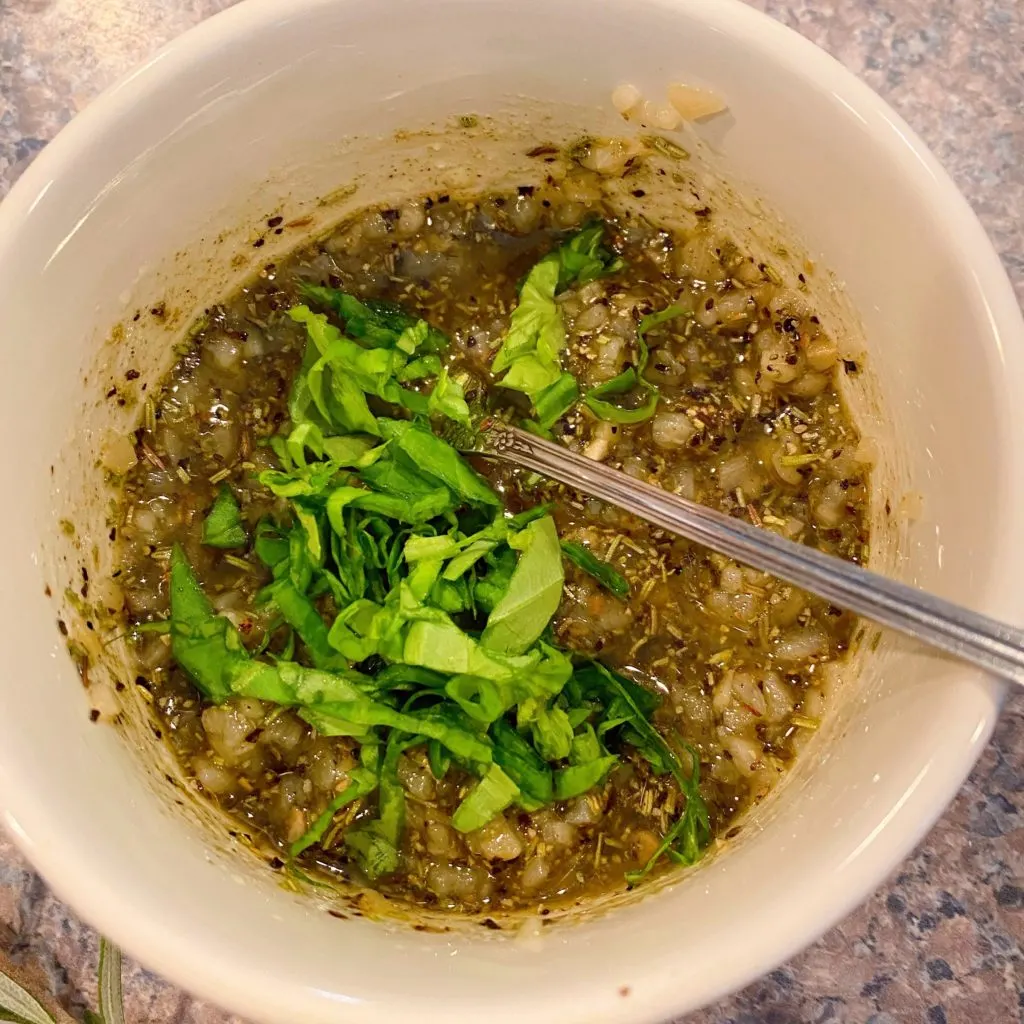 Adding fresh chopped basil to herb crust paste.