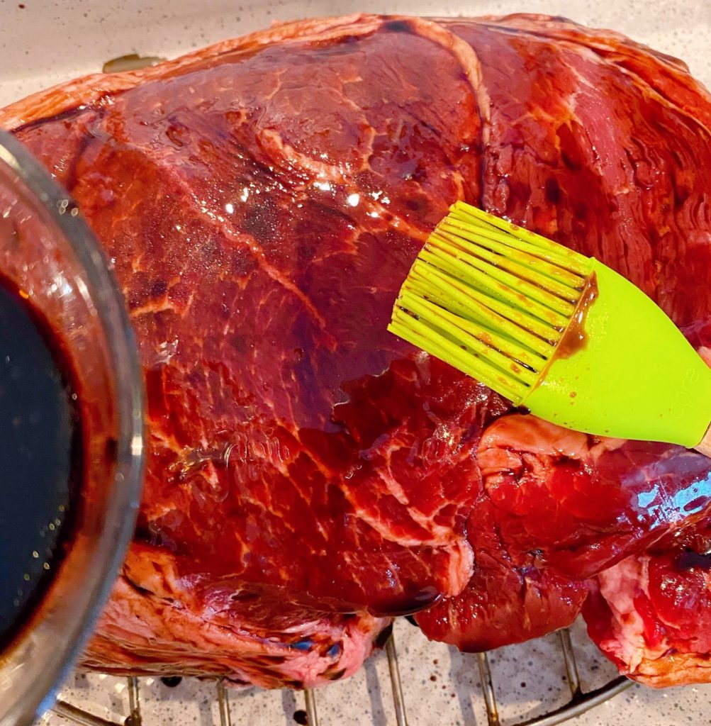 Brushing Cross Rib Roast with Balsamic Vinegar in roasting pan.