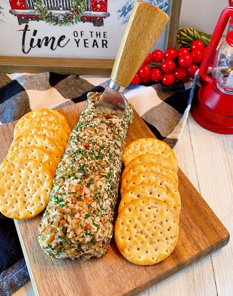 Salmon Party Log on a cutting board with crackers ready to serve.