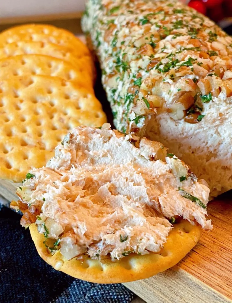 Salmon Party Log spread on a cracker ready to eat.