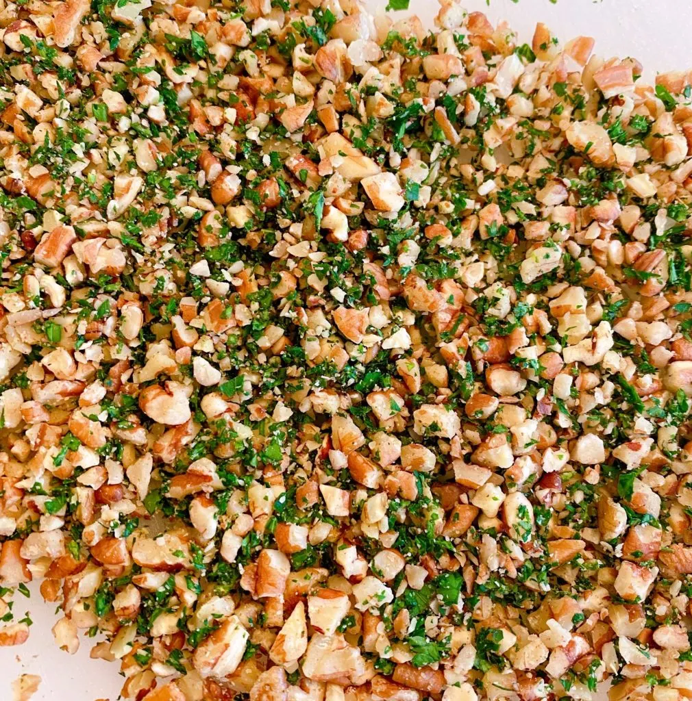 Chopped Pecans and Parsley on Parchment paper.