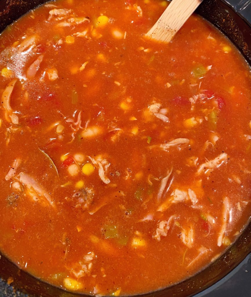 Stirring Slow Cooker Chicken Tortilla Soup before cooking.