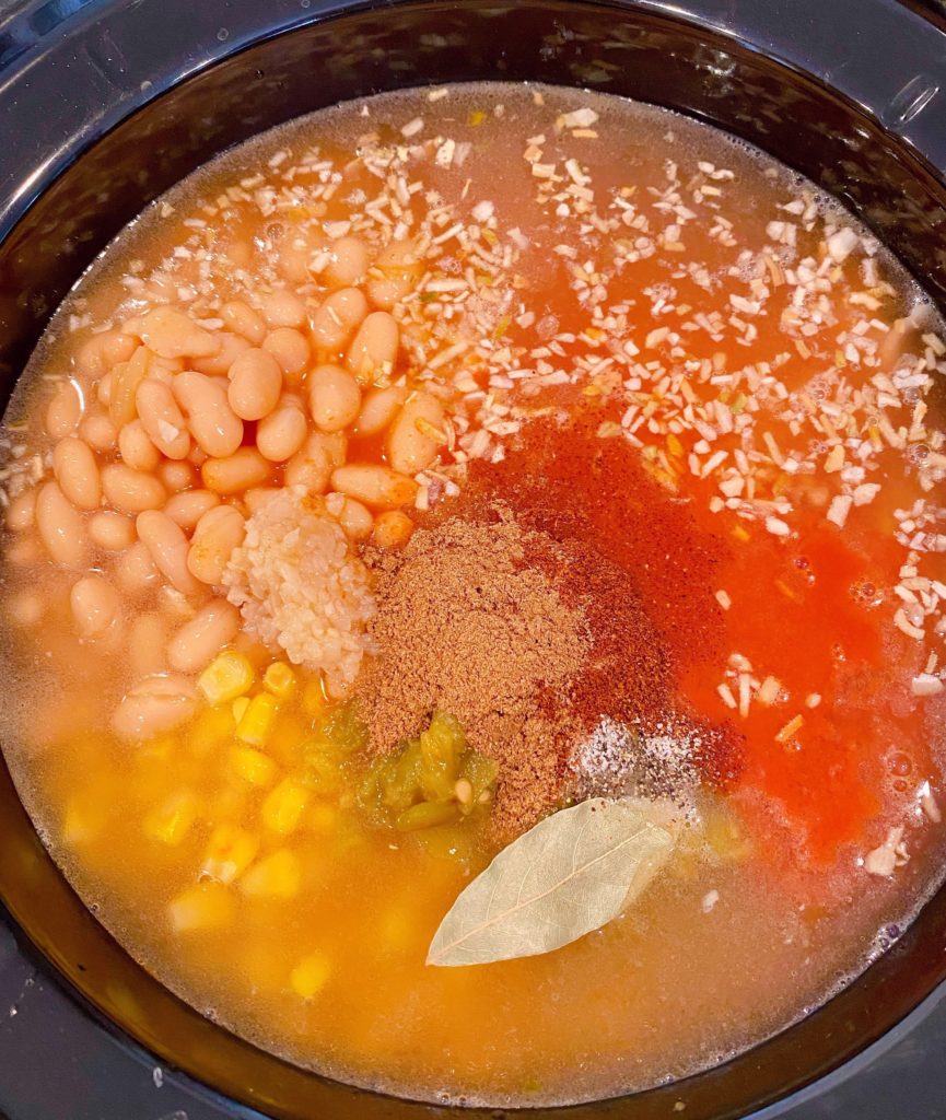 Adding seasonings to the slow cooker soup.