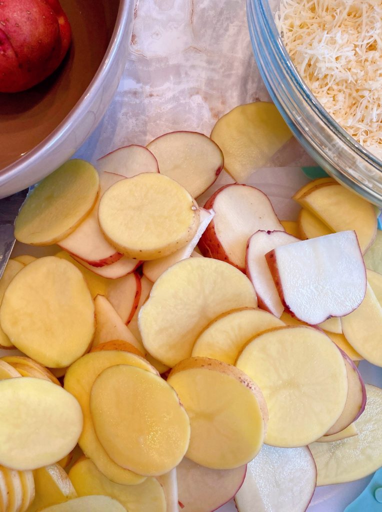 Potatoes sliced on a cutting board.