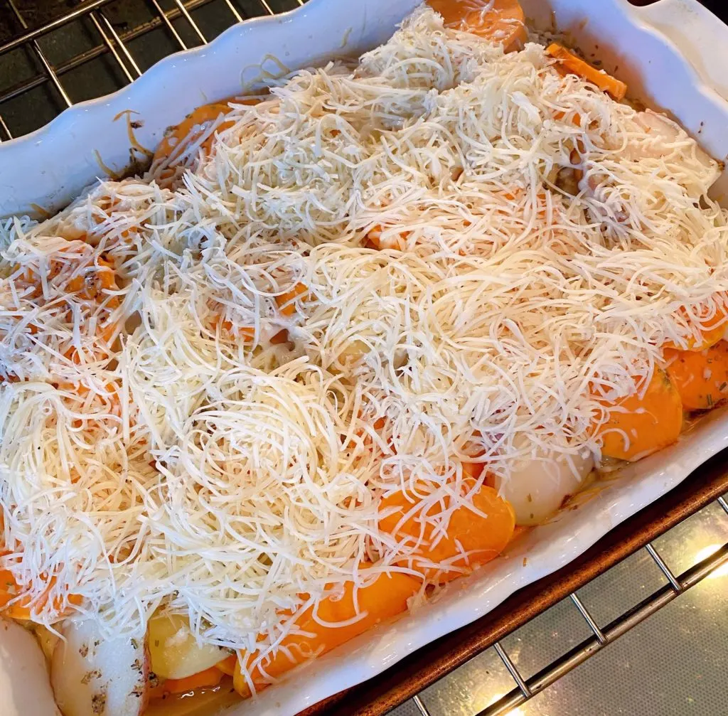 Three Potato Casserole with additional shredded cheese on top to finish baking.