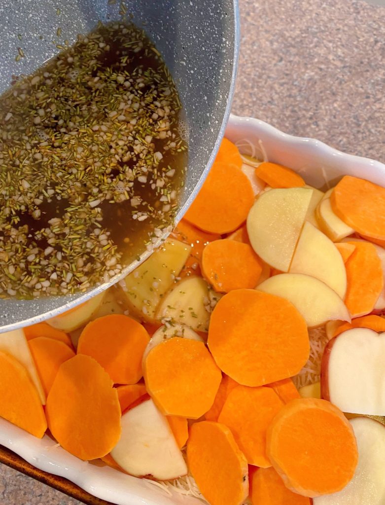 Pouring Beef broth over potatoes in baking dish.