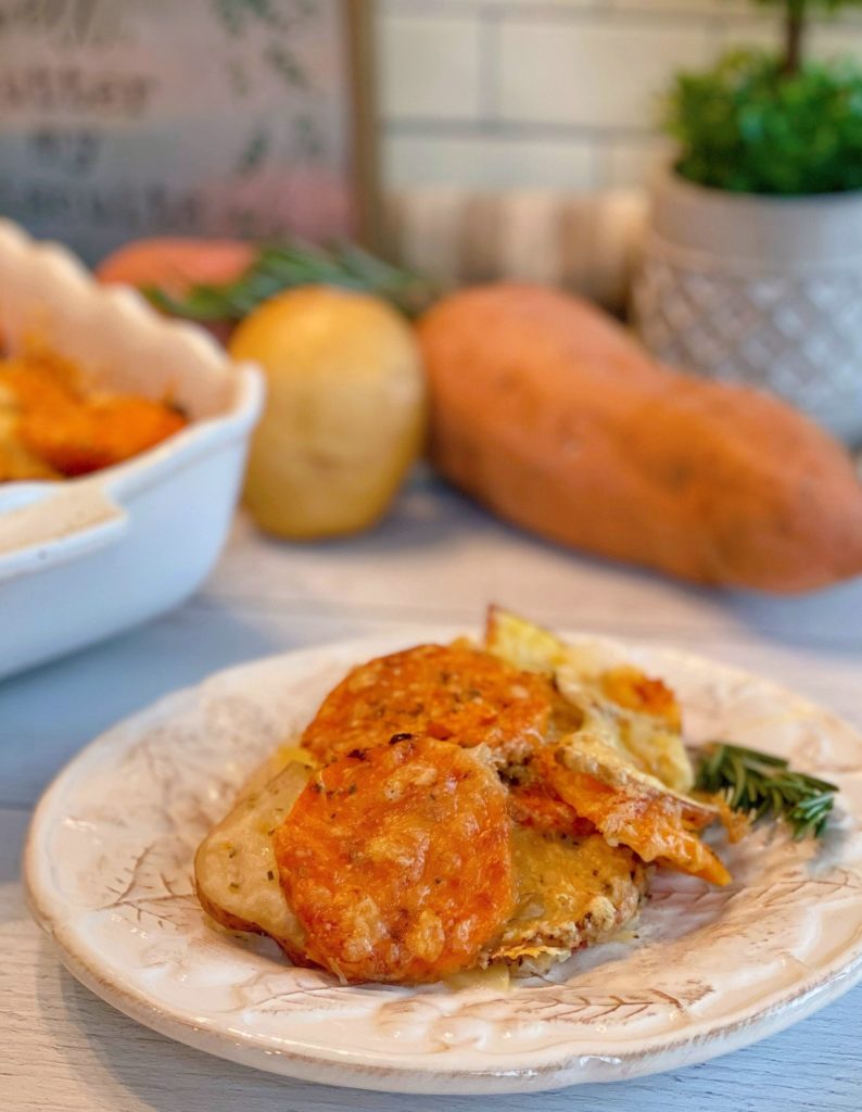 White plate with serving of Triple-Potato Gratin and sprig of Rosemary garnish.