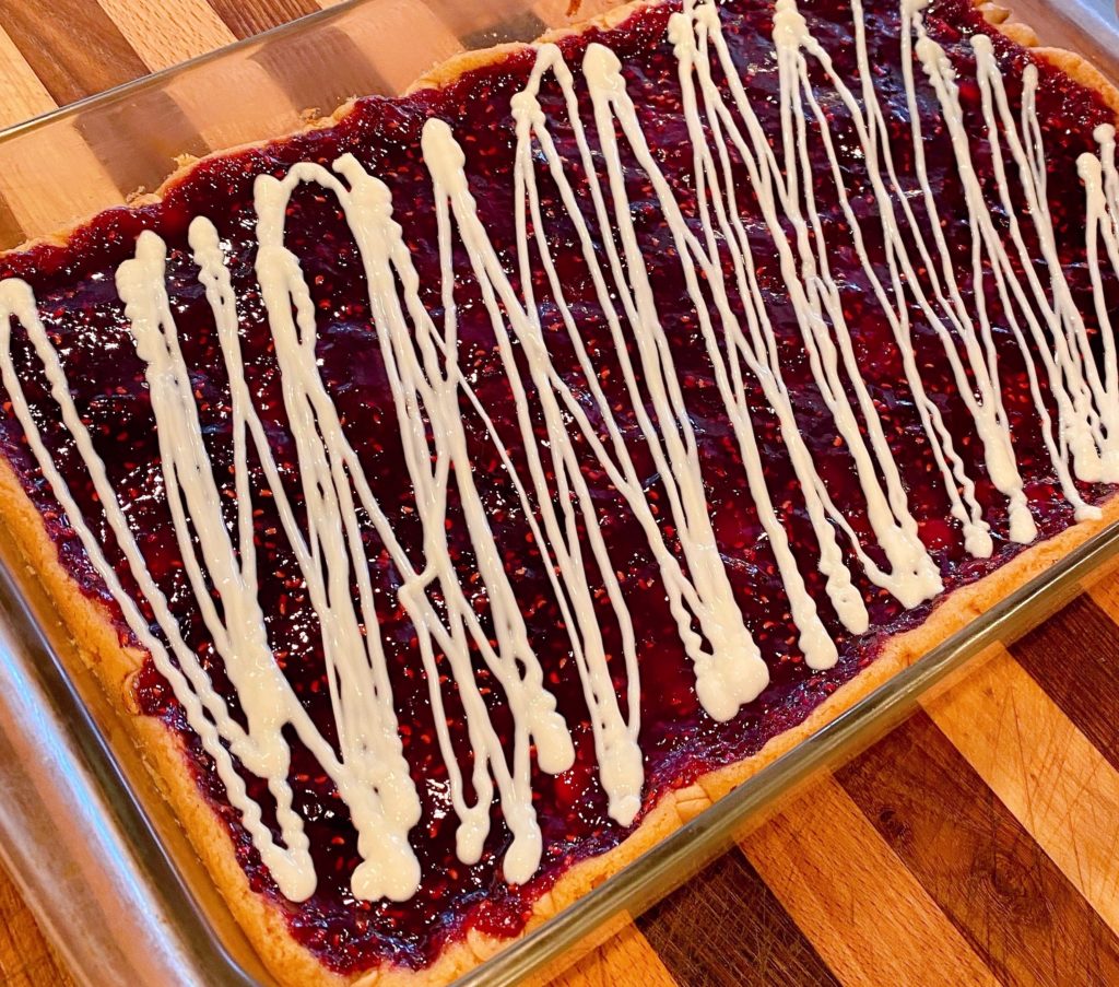 Drizzled White Chocolate Over Raspberry Bars.