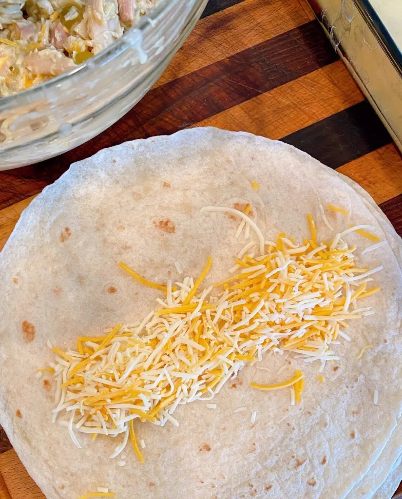 Shredded cheese down the center of each flour tortilla.