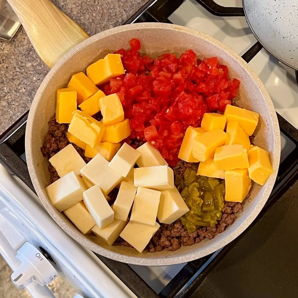 Adding Velveeta Cheese to the Queso.