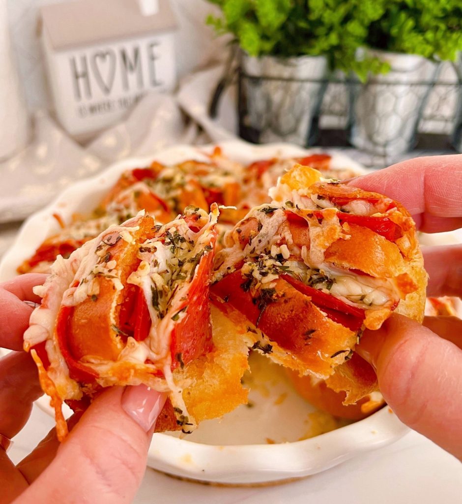 Baked Hasselback Pizza Sliders  being pulled apart.