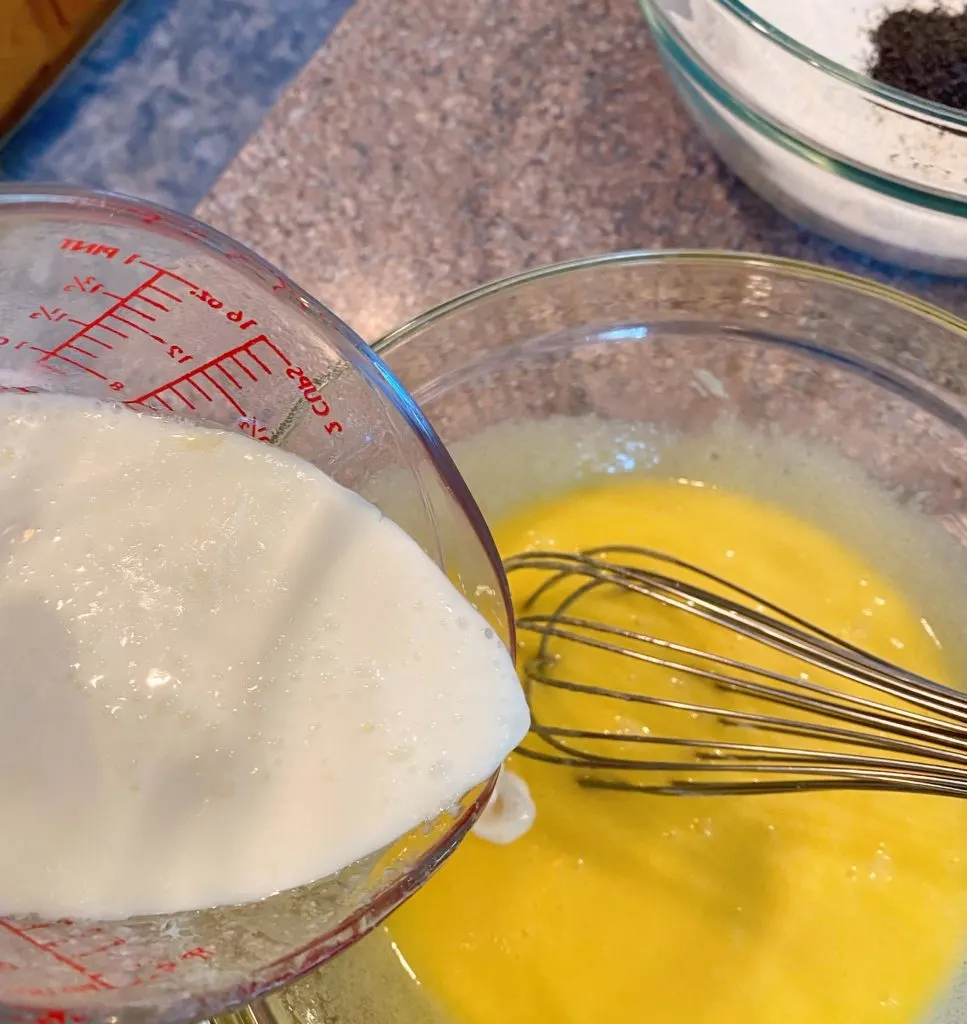 Slowly adding buttermilk to egg mixture with wire whisk.