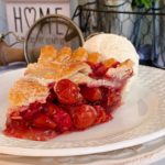 One Slice of Cherry Cranberry Raspberry Pie on a stack of white plates.