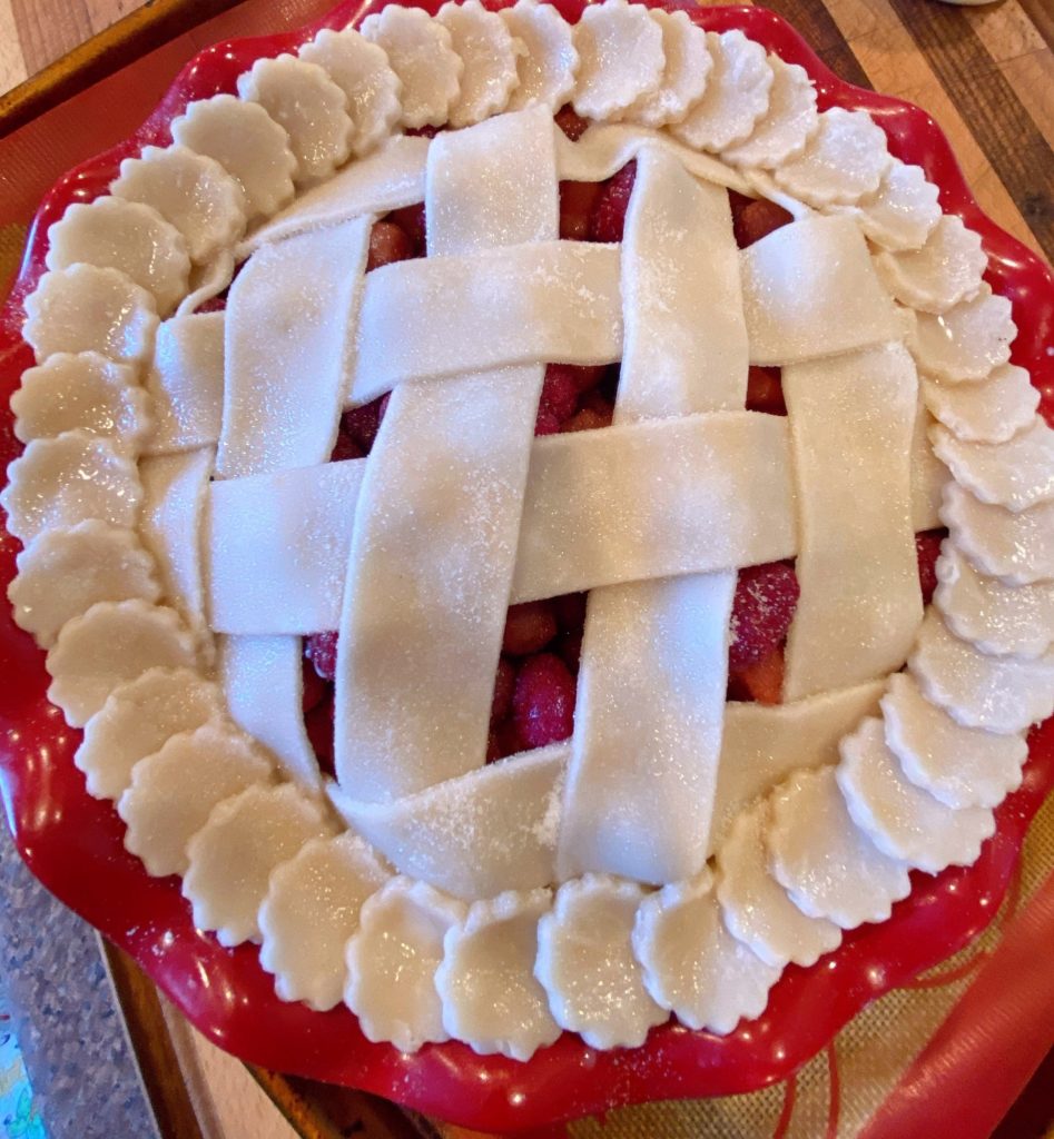 Pie ready to bake and on a baking sheet with silicone baking sheet.