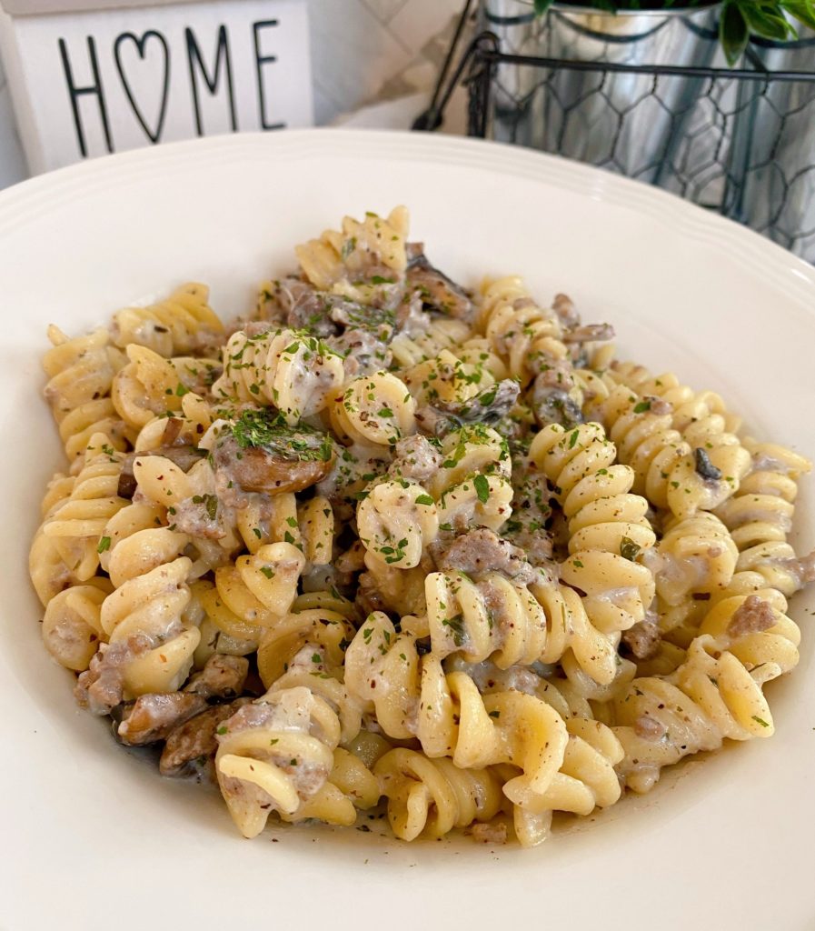 White shallow bowl full of a serving of Ground Beef Stroganoff.