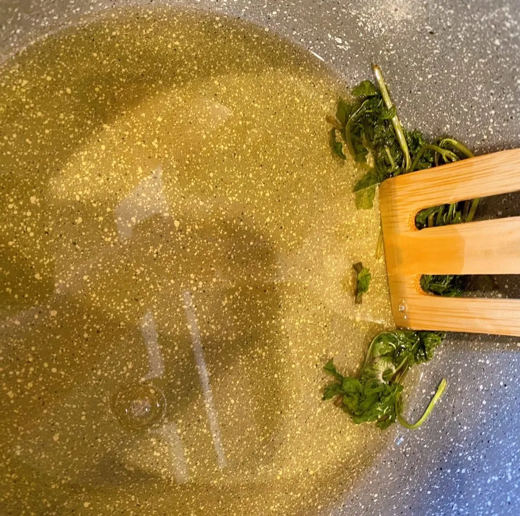 Pressing mint in sauce pan.