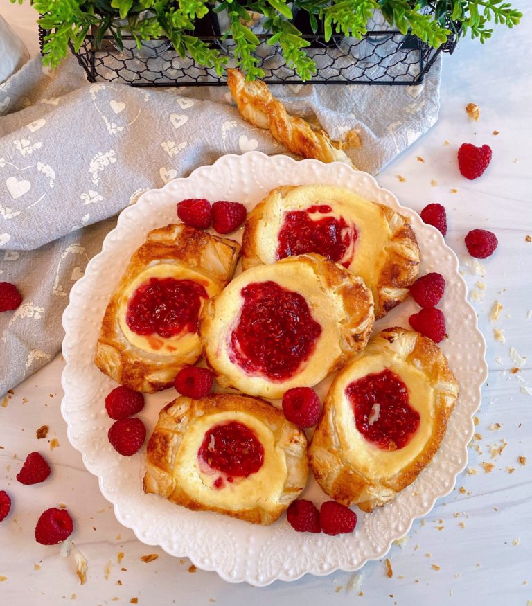 Plate full of Raspberry Cream Cheese Danish with fresh raspberries.