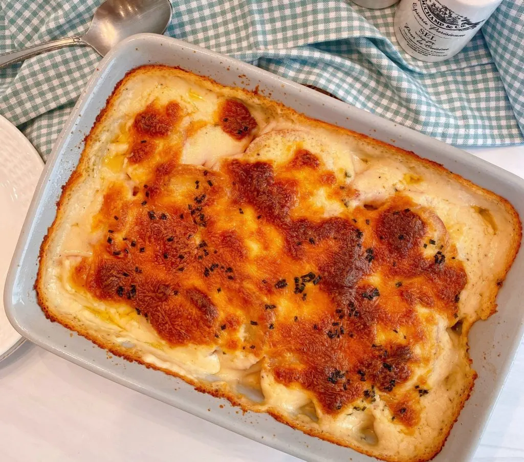Cheesy Au Gratin Potatoes in baking dish fresh out of the oven with a golden cheesy top.