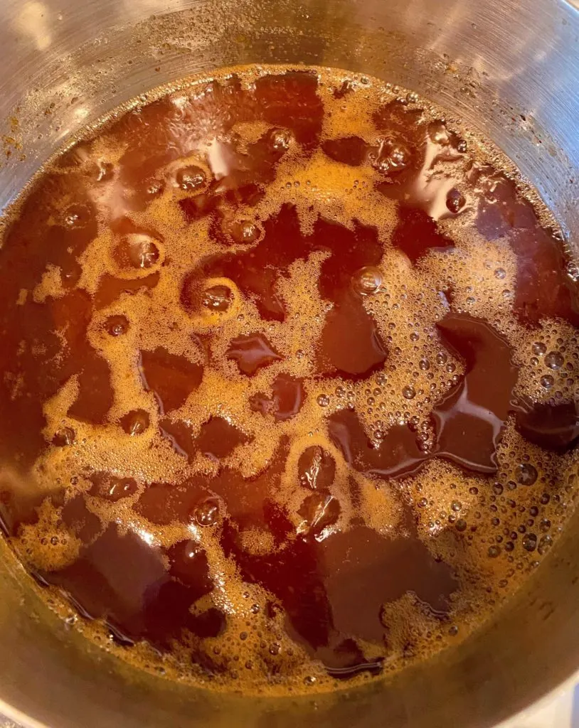 Dr Pepper Glaze reducing on low heat in a saucepan on top of the stove.