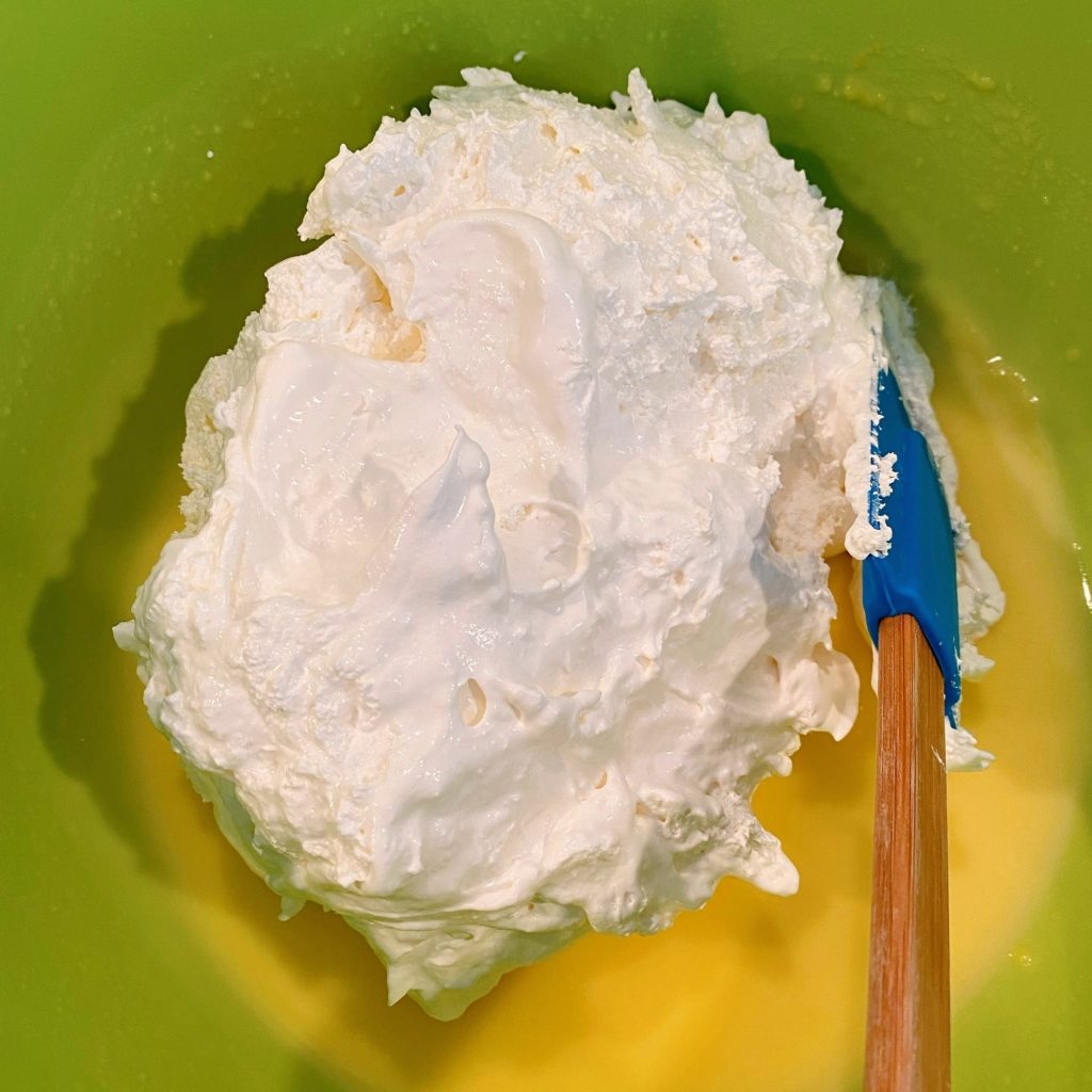 Adding cool whip to vanilla pudding.