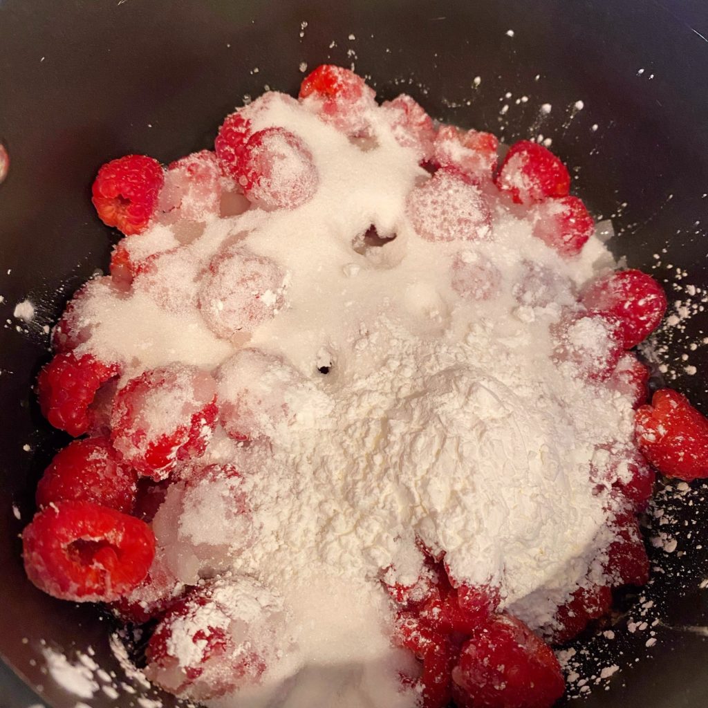 Ingredients for Raspberry Filling in sauce pan on stove top.