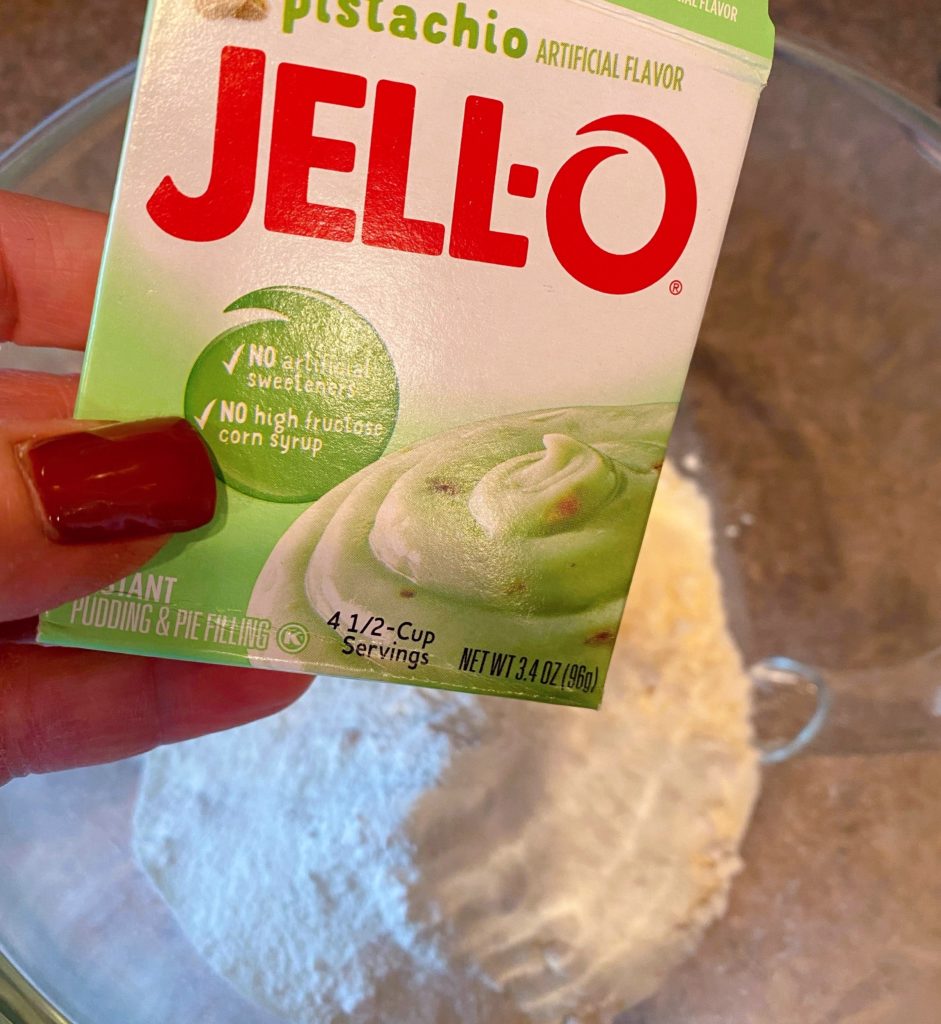 Adding Pistachio Pudding Mix  to cake mix.