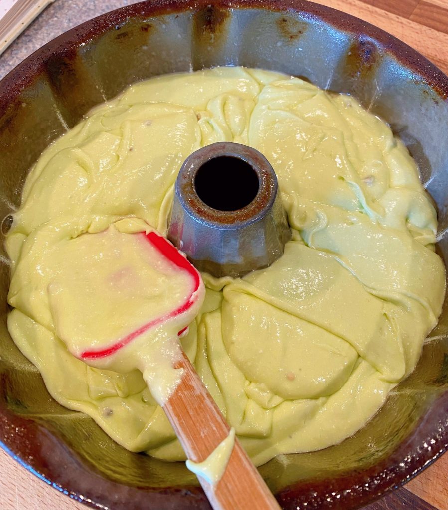 Spreading cake mix batter in bundt pan using a rubber spatula.