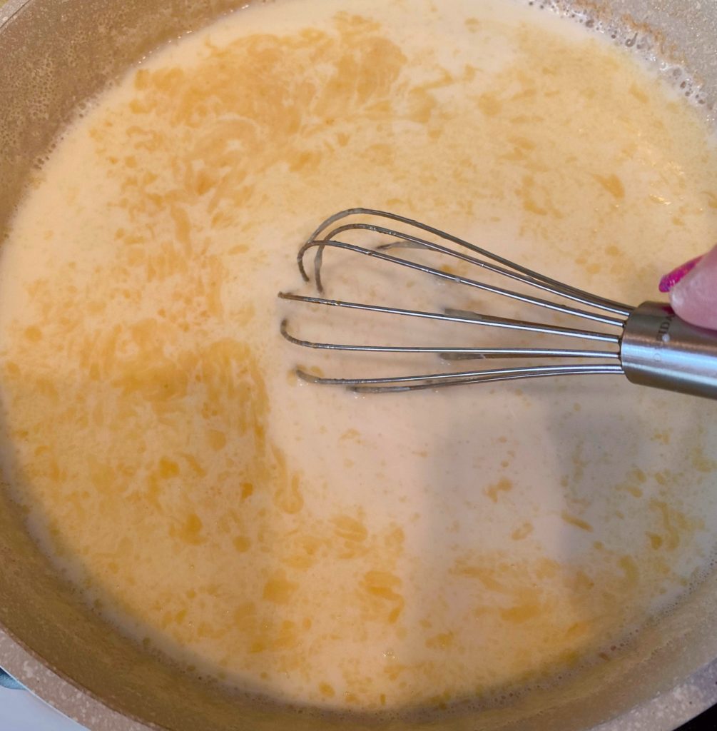 Whisking milk into flour mixture.