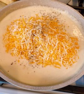 Adding Cheese to cream sauce.