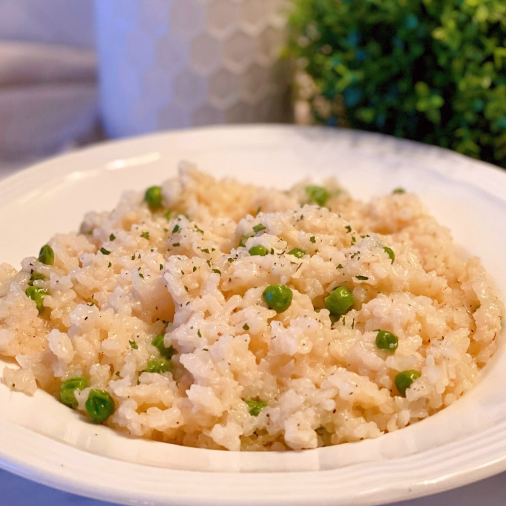 One Pot Oven Parmesan Risotto in a white bowl with peas. 