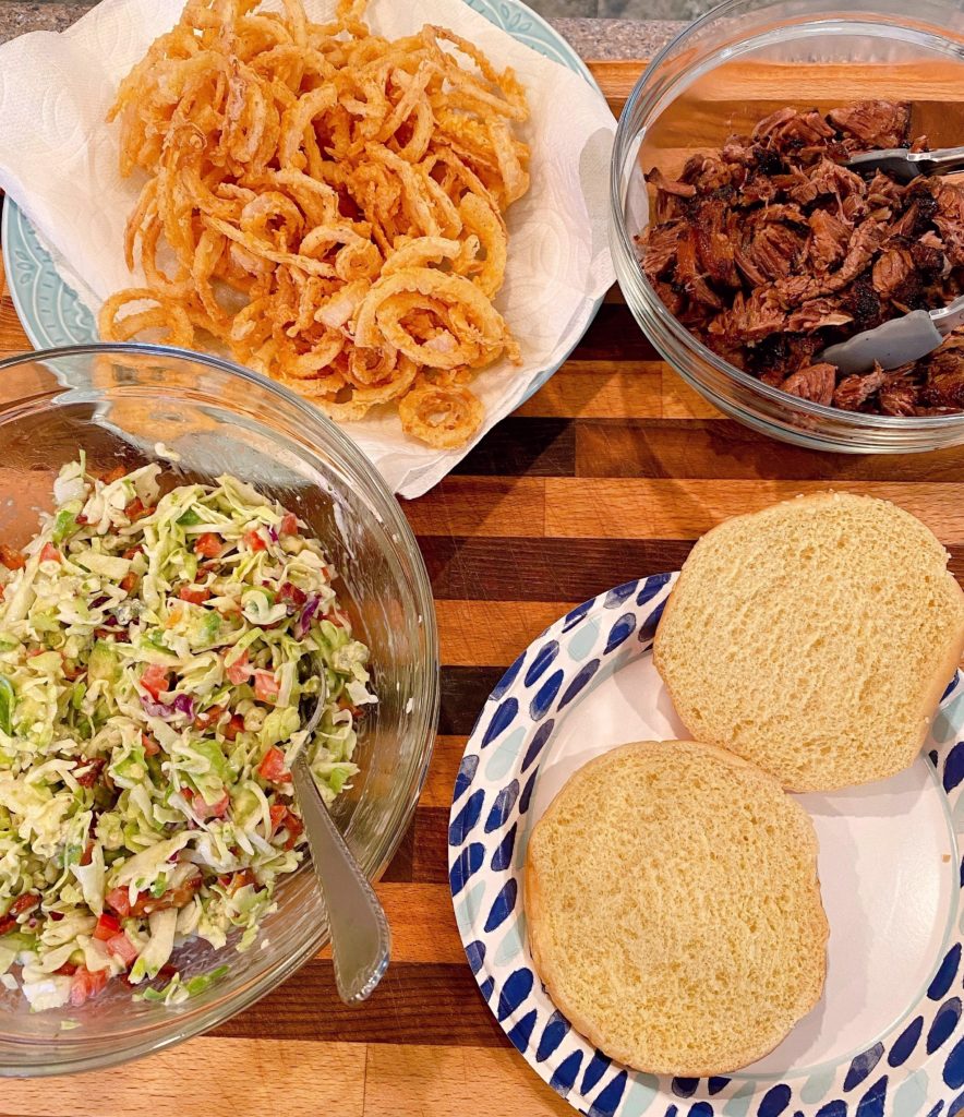 Ingredients for Short Rib Beef Sandwiches gathered on a large cutting board.