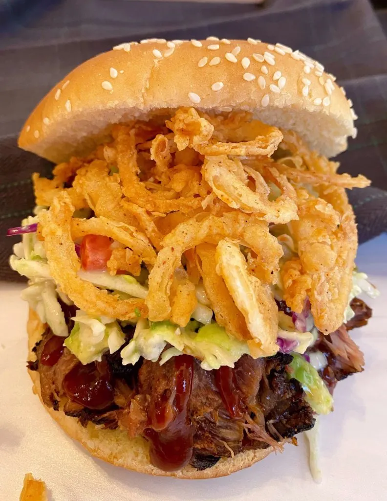 Adding Shoestring Onion Straws on top of slaw and beef short ribs.