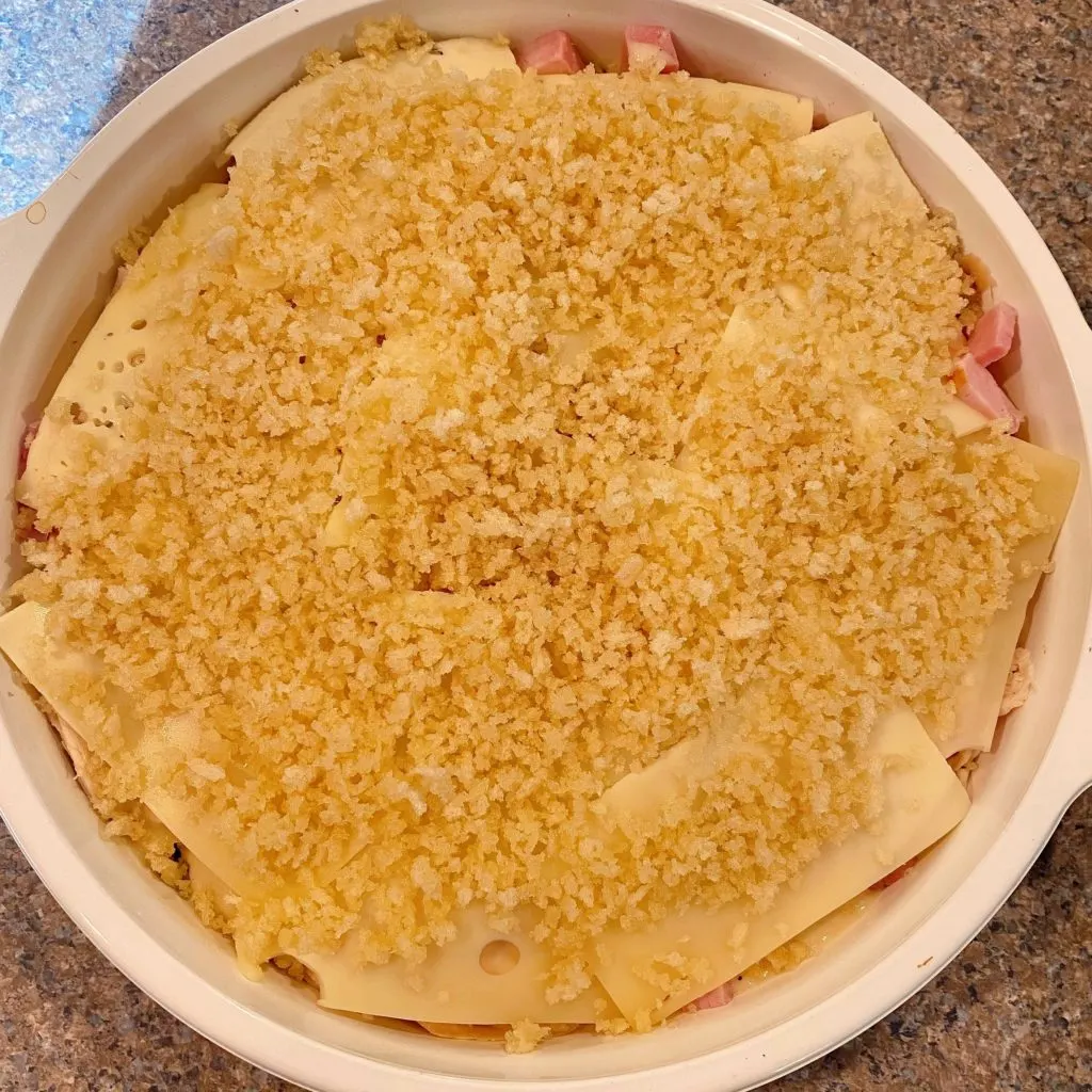 Panko crumbs on top of cheese in casserole dish.