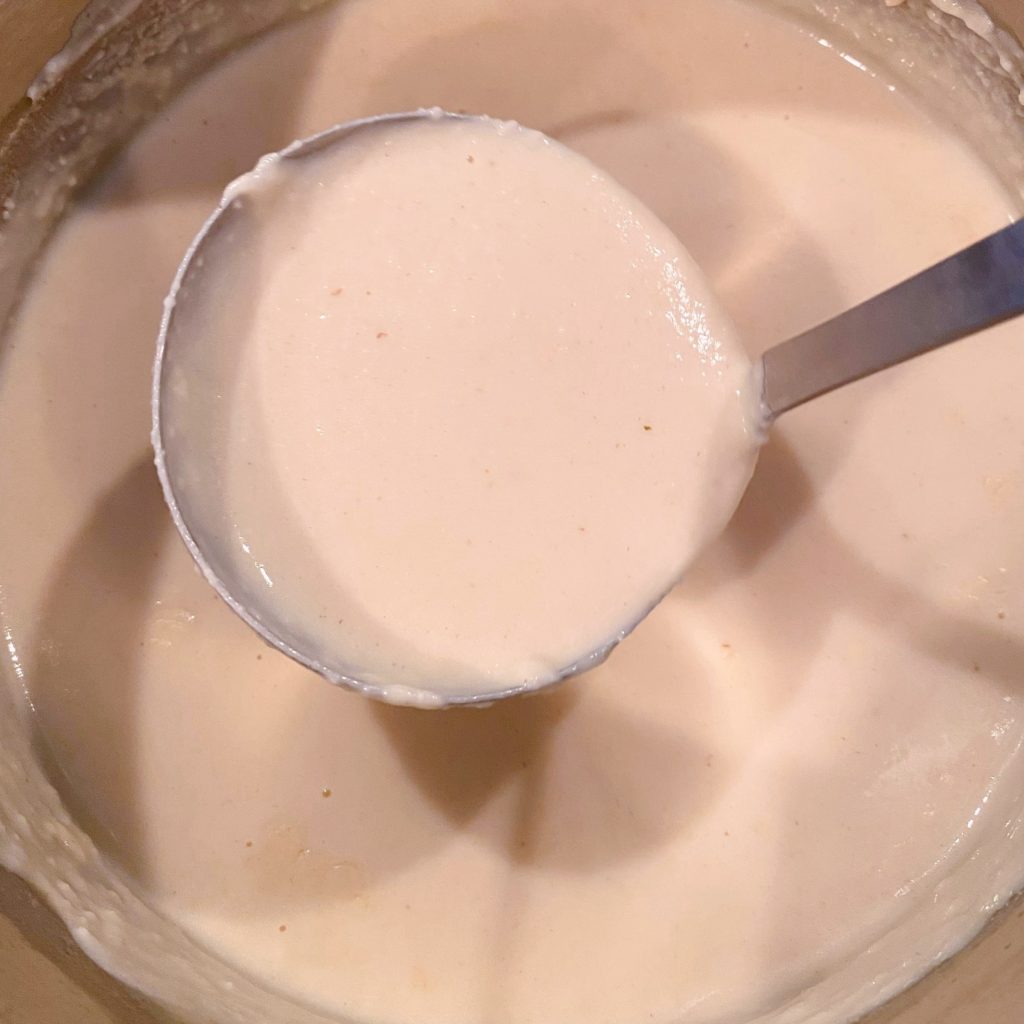 Cream Sauce in a ladle in the sauce pan.