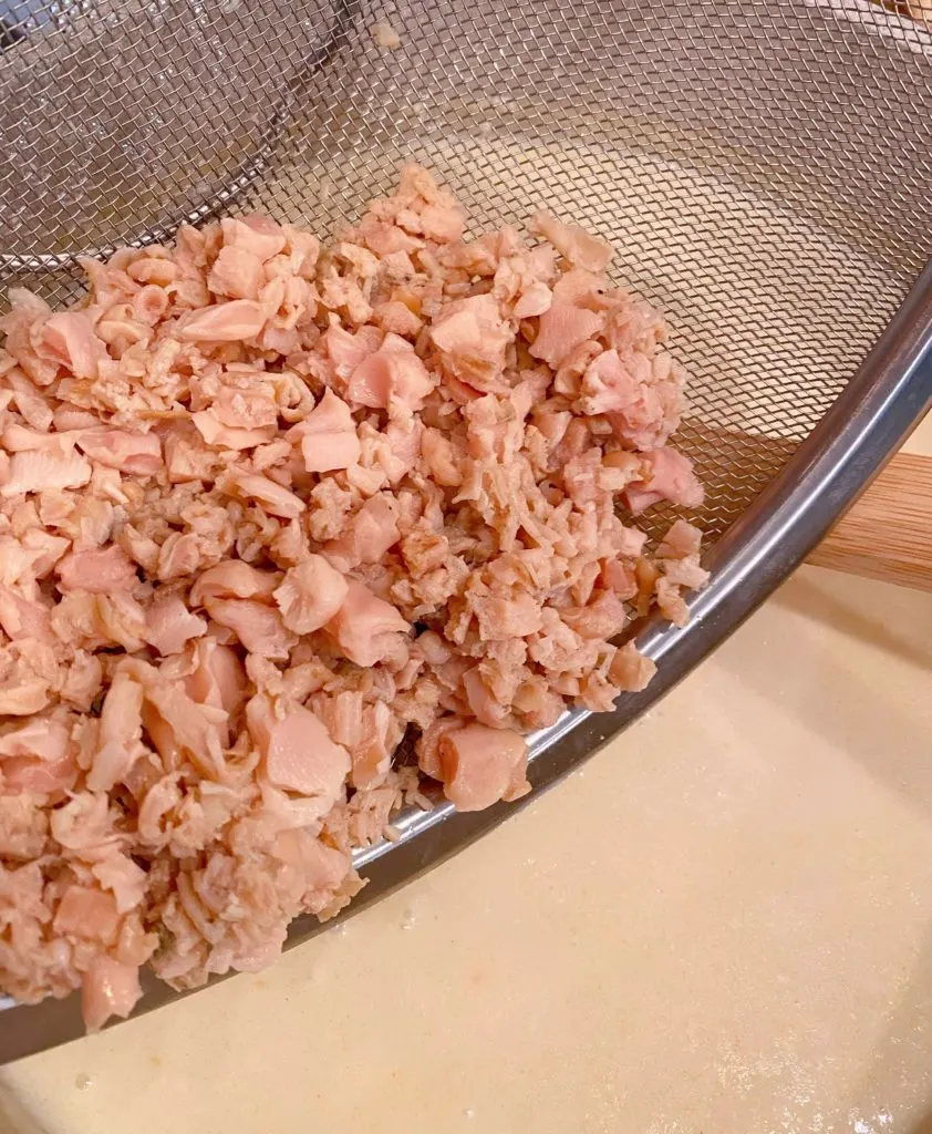 Adding clams to chowder mixture.