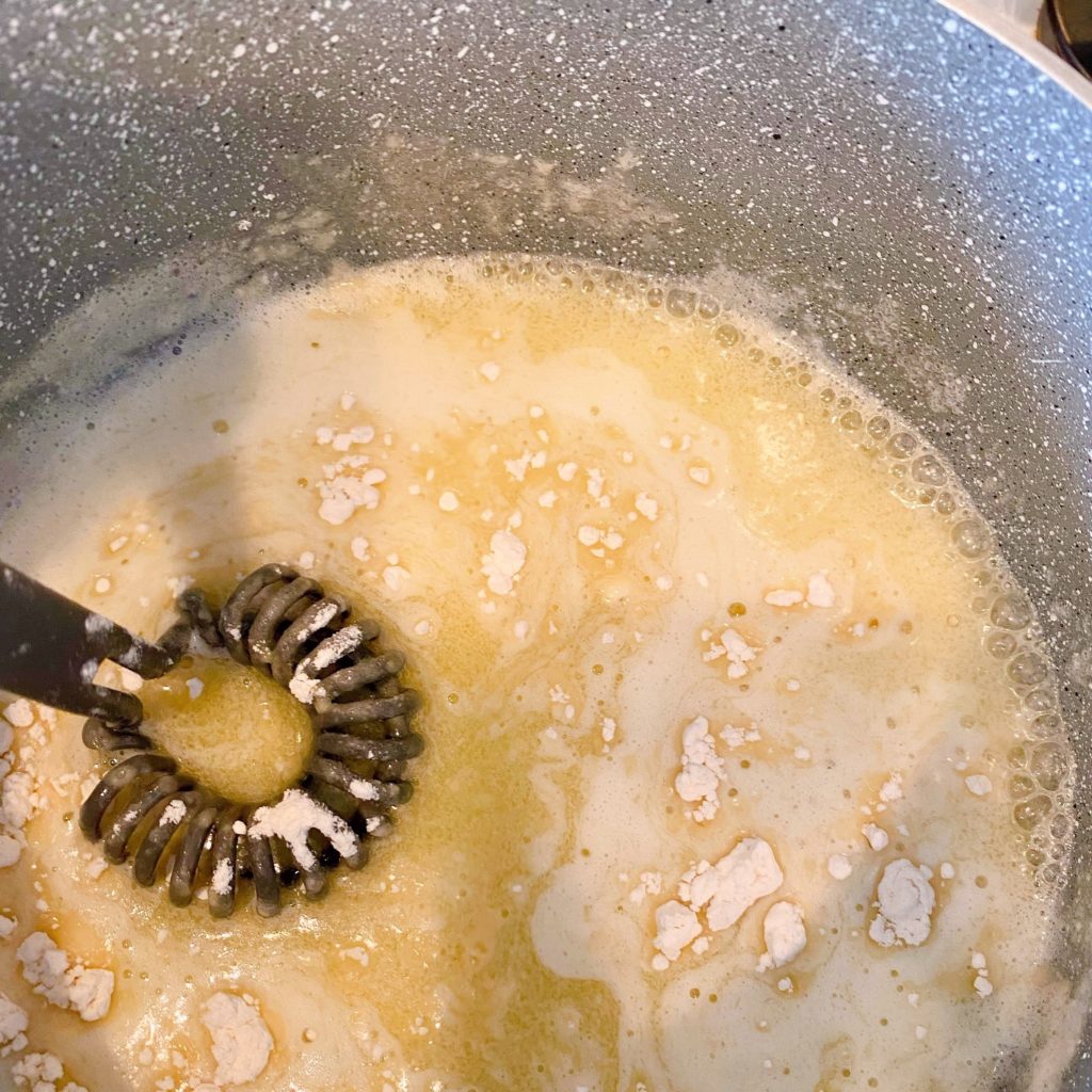 Adding flour to melted butter in sauce pan.