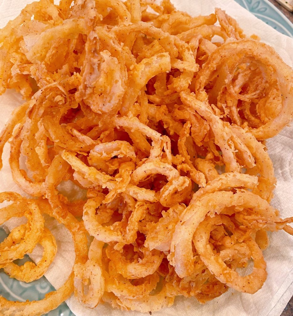 Onion Straws on a paper  towel-lined plate.