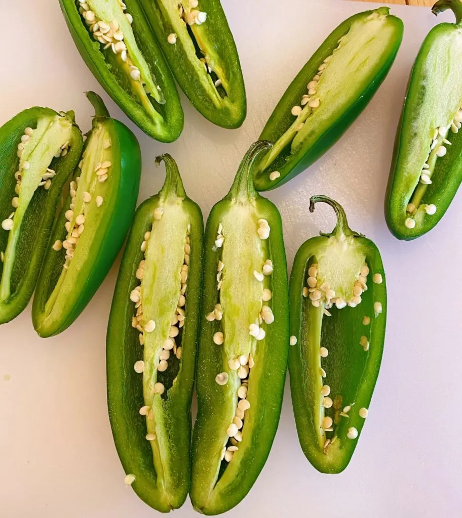Jalapeno peppers cut lengthwise with seeds exposed.