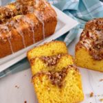 Slices of Lemon Streusel Bread with whole loaves in the background.