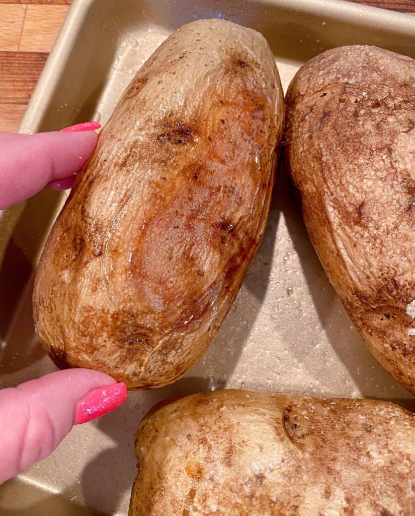 Baked Potato turned over to expose the bottom of the baked potato showing golden skins.