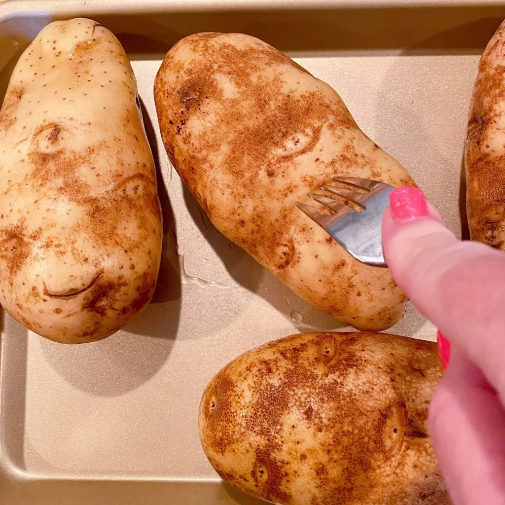 Piercing potatoes with a fork.