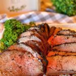 Sliced Tri-tip on a white serving platter.