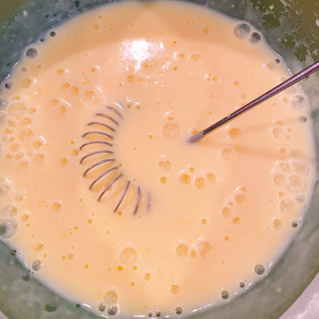 Mixing pudding and milk in large bowl with wire whisk.