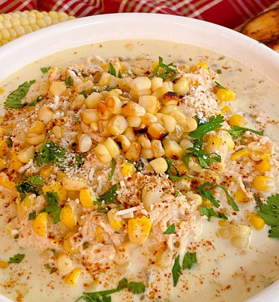 Chicken Corn Chowder in a large white bowl topped with more corn and cheese.