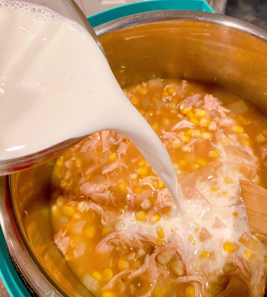 Adding Cream to Corn Chowder in the Instant Pot.